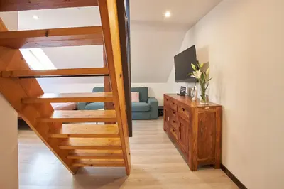 a wooden staircase in a living room with a blue couch at Rybna - Old Town Residence in Prague