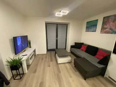 a living room with a couch and a flat screen tv at Apartmány Krymlov in Oleška