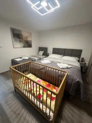 a room with two beds and a crib at Apartmány Krymlov in Oleška