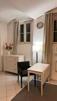 a living room with a table and a chair at Prague Castle Garden Residence in Prague