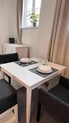 a white table with two plates and wine glasses on it at Prague Castle Garden Residence in Prague