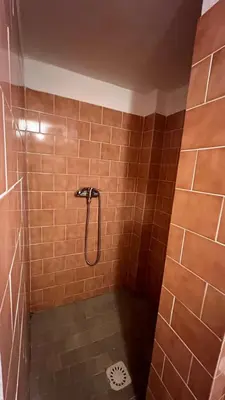 a bathroom with a shower with brown tiles at Prague Castle Garden Residence in Prague