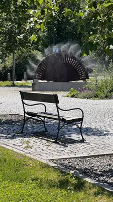 a park bench sitting in front of a fountain at Prague Castle Garden Residence in Prague