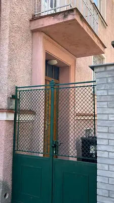a green door on a building with a balcony at Prague Castle Garden Residence in Prague