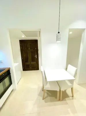 a white dining room with a white table and chairs at Fantastic location! SUPERHOST 5 STAR in Prague