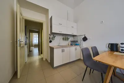 a kitchen with white cabinets and a table and chairs at T&T Homestay in Prague