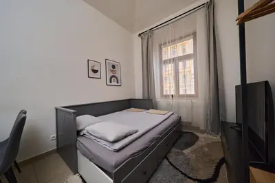 a small bedroom with a bed and a television at T&T Homestay in Prague