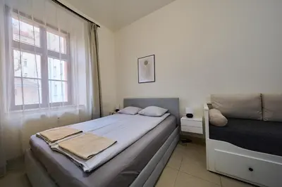 a small bedroom with a bed and a window at T&T Homestay in Prague