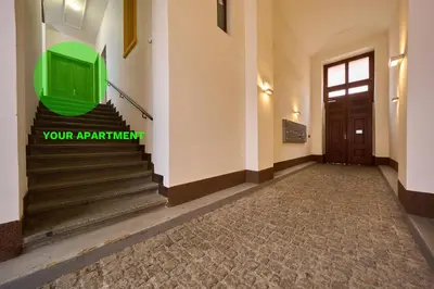 a hallway with stairs and a green tv on the wall at T&T Homestay in Prague