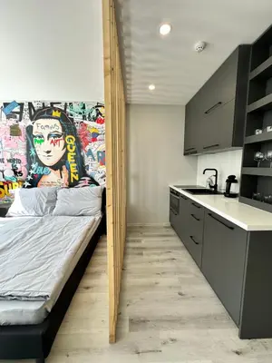 a room with a bed and a kitchen with a counter at IOS ArtPrg in Prague