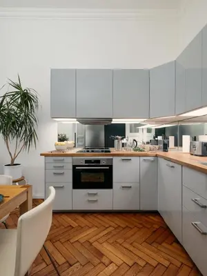 a kitchen with white cabinets and a wooden floor at Comfortable and cosy apt a few steps from Dancing House and Naplavka Dance in Prague