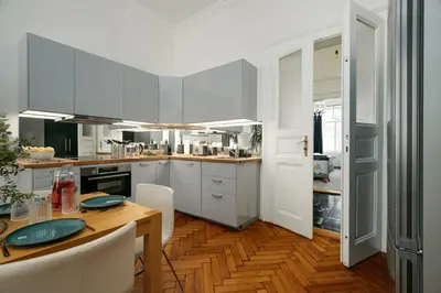 a kitchen with white cabinets and a wooden table at Comfortable and cosy apt a few steps from Dancing House and Naplavka Dance in Prague