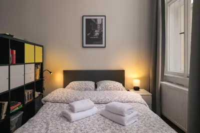 a bedroom with a bed with two white towels on it at Comfortable and cosy apt a few steps from Dancing House and Naplavka Dance in Prague