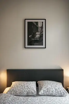 a bedroom with a bed with a picture on the wall at Comfortable and cosy apt a few steps from Dancing House and Naplavka Dance in Prague