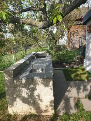 a concrete sink in a yard under a tree at Záhradní chata Kbelská 335 in Prague