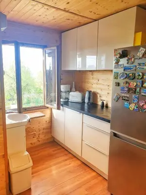 a kitchen with white cabinets and a refrigerator with magnets at Záhradní chata Kbelská 335 in Prague