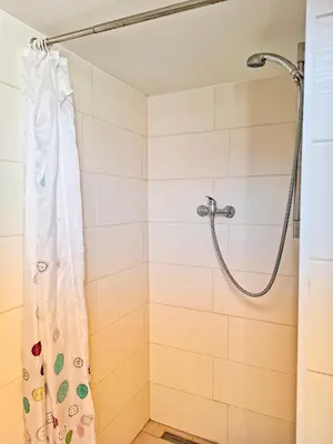 a shower with a shower curtain in a bathroom at Záhradní chata Kbelská 335 in Prague