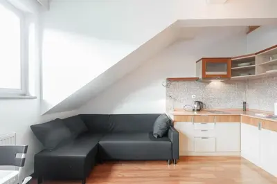 a black couch in a living room with a kitchen at Dream city in Prague