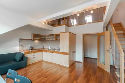 an open kitchen and living room with a blue couch at Dream city in Prague