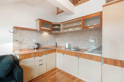a small kitchen with white cabinets and wooden counters at Dream city in Prague