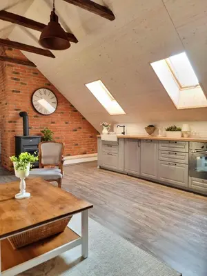 a kitchen with a table and a clock on the wall at Apartmán u Stef in Borotice