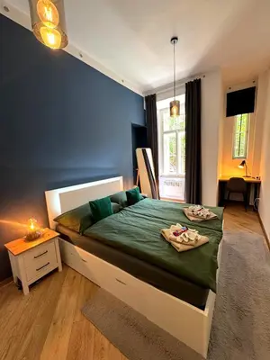 a bedroom with a bed with a green comforter at Modern Apartment in the Heart of Vršovice in Prague