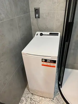 a small white refrigerator in a corner of a room at Modern Apartment in the Heart of Vršovice in Prague