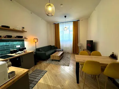 a living room with a table and yellow chairs at Modern Apartment in the Heart of Vršovice in Prague