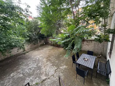 a patio with a table and chairs and trees at Modern Apartment in the Heart of Vršovice in Prague
