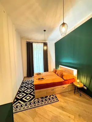 a bedroom with a bed and a green wall at Modern Apartment in the Heart of Vršovice in Prague