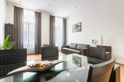 a bedroom with a white bed with a painting on the wall at Riverside Palace Apartments in Prague