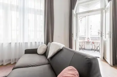 a living room with a couch and a large window at Riverside Palace Apartments in Prague