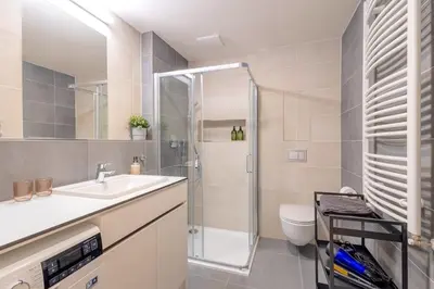 a bathroom with a shower and a sink and a toilet at Bright 2BR - 8th floor, Balcony, Free Parking - by Gravity Prague in Prague