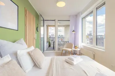 a bedroom with a large white bed and a balcony at Bright 2BR - 8th floor, Balcony, Free Parking - by Gravity Prague in Prague