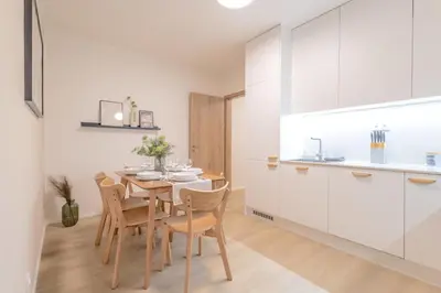 a kitchen and dining room with a table and chairs at Bright 2BR - 8th floor, Balcony, Free Parking - by Gravity Prague in Prague