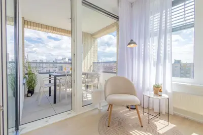 a living room with a chair and a balcony at Bright 2BR - 8th floor, Balcony, Free Parking - by Gravity Prague in Prague