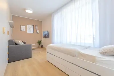 a bedroom with a bed and a couch and a window at Bright 2BR - 7th floor, Balcony, Free Parking by Gravity Prague in Prague