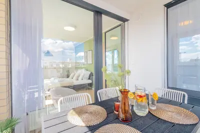 a wooden table with straw hats and glasses on a balcony at Bright 2BR - 7th floor, Balcony, Free Parking by Gravity Prague in Prague