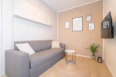 a living room with a couch and a tv at Bright 2BR - 7th floor, Balcony, Free Parking by Gravity Prague in Prague