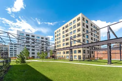 a large white building with a grassy field in front of it at Bright 2BR - 7th floor, Balcony, Free Parking by Gravity Prague in Prague