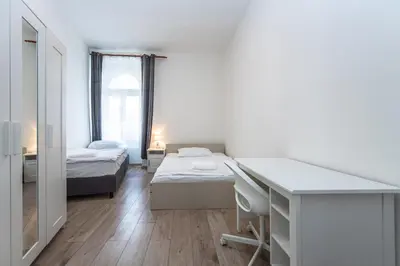 a white room with two beds and a desk and a desk at Apartment Charkovska 18 in Prague