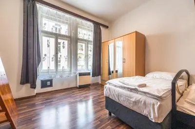 a bedroom with a bed and a large window at Apartment Charkovska 18 in Prague