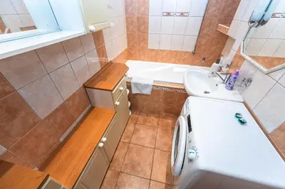 a bathroom with a sink and a washing machine at Apartment Charkovska 18 in Prague
