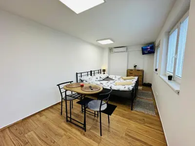 a room with a bed and a table and chairs at Útulný apartmán v klidné části Benešova in Benešov