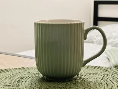 a white coffee cup sitting on a table at Útulný apartmán v klidné části Benešova in Benešov