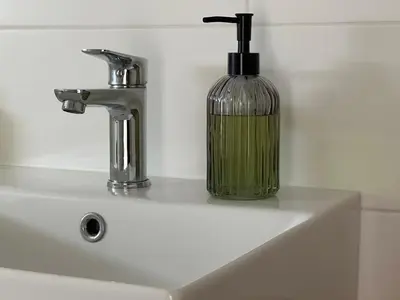 a soap dispenser sitting on top of a sink at Útulný apartmán v klidné části Benešova in Benešov
