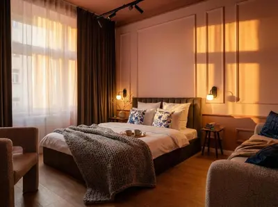 a bedroom with a bed and a blue couch at TurnKey I Antonin Dvorak Apartments in Prague