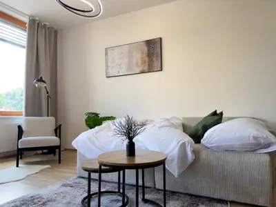 a living room with a bed and a table at Central Riverside Apartment - Free Parking in Prague
