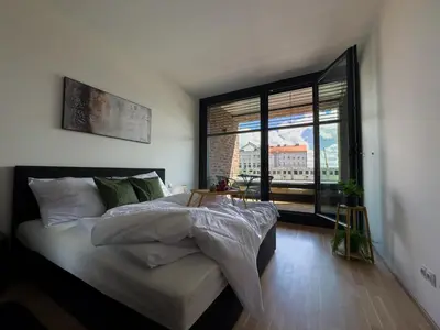 a bedroom with a large bed and a large window at Central Riverside Apartment - Free Parking in Prague