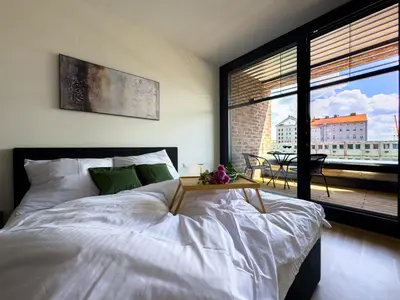 a bedroom with a large white bed and a balcony at Central Riverside Apartment - Free Parking in Prague